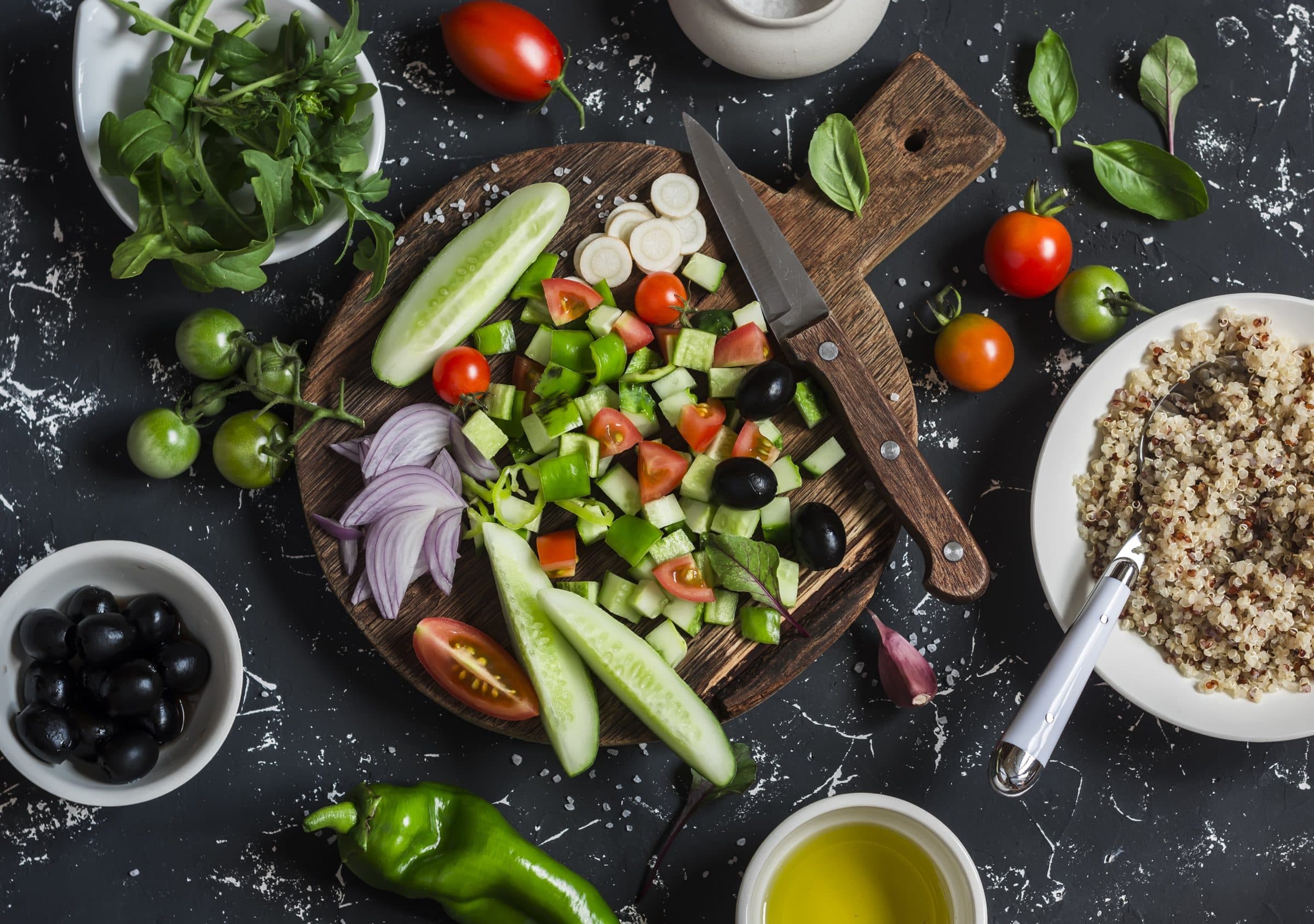 Fresh vegetables, herbs and grains being prepared on a kitchen counter